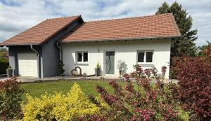 a white house with a red roof at Au Jardin Secret in Rimsdorf