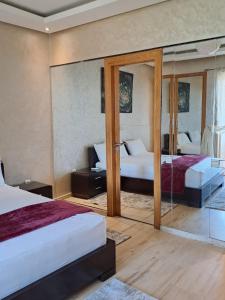 une chambre avec deux lits et un miroir dans l'établissement Séjour Prestige Vue Mer, Jacuzzi, Piscine, à Oulad Akkou 19 autres photos