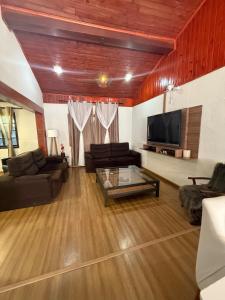 a living room with a couch and a tv at Casa Marrom dos Mellos, Campos do Jordão in Campos do Jordão