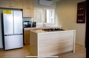 a kitchen with a white refrigerator and a stove at Tropical Views - Luxury Live #The Best Views #Walk to The Beach in San Juan del Sur +18 photos