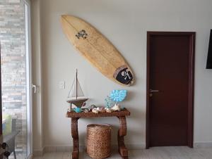 a surfboard hanging on a wall next to a table at Tropical Views - Luxury Live #The Best Views #Walk to The Beach in San Juan del Sur