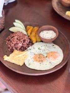 a plate of food with two eggs and other foods at Tropical Views - Luxury Live #The Best Views #Walk to The Beach in San Juan del Sur
