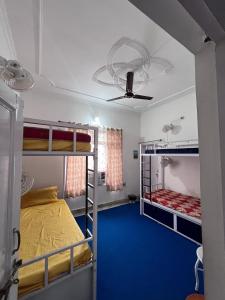 a room with two bunk beds and a blue floor at Wild Sapiens Station in Jammu
