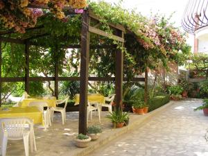 a pergola with tables and chairs and flowers at Apartment Kukljica 7 in Kukljica