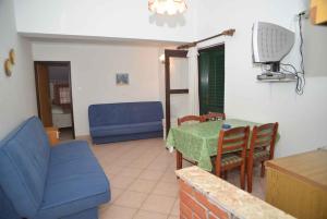a living room with a table and a blue couch at Apartment Kukljica 7 in Kukljica