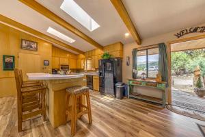 a kitchen with wooden floors and a counter and a refrigerator at Rustic Alto Cabin with Hot Tub, Deck and Fireplace! in Alto