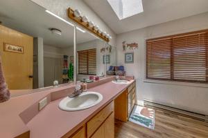 a bathroom with two sinks and a large mirror at Rustic Alto Cabin with Hot Tub, Deck and Fireplace! in Alto +32 photos