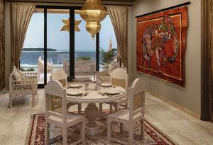 a dining room with a table and chairs with a view of the ocean at Shah Palace Zanzibar - All Suites in Matemwe