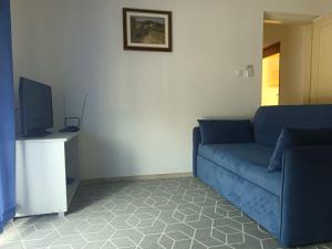 a living room with a blue couch and a tv at Apartments Lukacic in Tkon