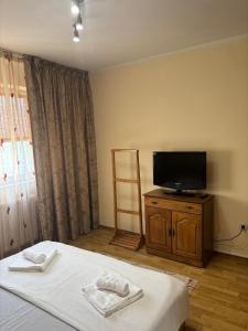 Un dormitorio con una cama y un televisor de pantalla plana. en Ap 3 camere decomandate in apropiere de plaja Perla, Constanta, en Colentina