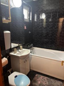 Un baño con bañera, inodoro y lavabo. en Ap 3 camere decomandate in apropiere de plaja Perla, Constanta, en Colentina