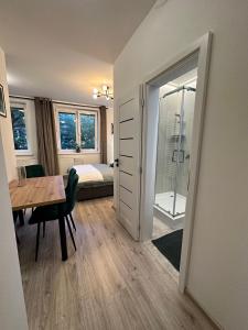 a room with a table and a bedroom with a bed at Apartments Albi in Liptovský Mikuláš