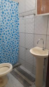 a bathroom with a toilet and a sink at Kitnet jardim Campomar in Rio das Ostras