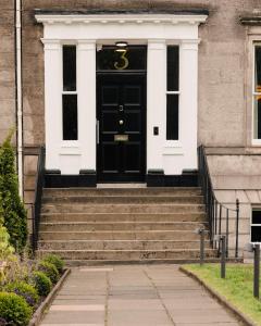 a black door on a building with stairs at 3 John's Place Townhouse in Edinburgh