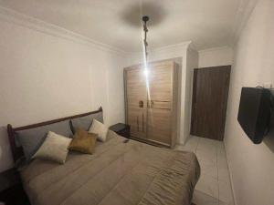 a bedroom with a bed with a light above it at complexe Jawharat tetouan in Tétouan