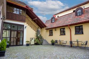 a building with chairs and tables in a courtyard at Apartmán Vikárka - dům Karla Hynka Máchy - Litoměřice in Litoměřice