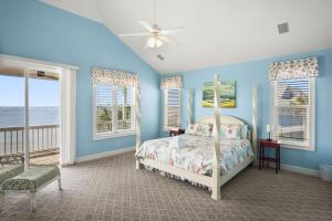 a bedroom with a bed and a balcony with the ocean at 12 Sea Mist in Fripp Island +64 photos