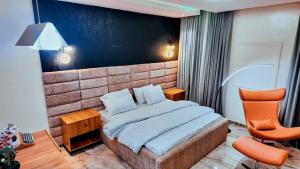 a bedroom with a bed and a chair in it at Redbox Luxury Apartments in Port Harcourt