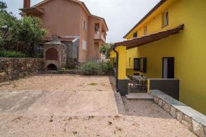 a yellow house with a patio and a building at Apartment Vrbnik 21 in Vrbnik +14 photos