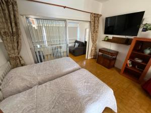 a bedroom with a bed and a flat screen tv at Trebol 1 in Costa Del Silencio