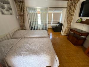 a bedroom with two beds and a couch and a television at Trebol 1 in Costa Del Silencio