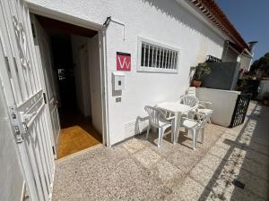 a white table and chairs next to a building at Trebol 1 in Costa Del Silencio