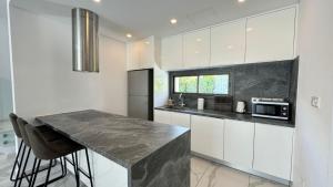 a kitchen with white cabinets and a black counter top at Modern 3 bedroom villa with pool in Paphos City