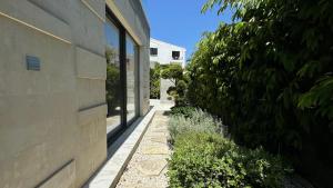 a walkway next to a building next to a bush at Modern 3 bedroom villa with pool in Paphos City +15 photos