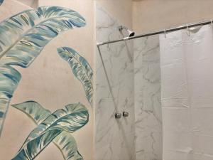 a bathroom with a shower with a mural of a palm tree at Sakti, the best location in Bacalar +11 photos