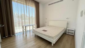 a bedroom with a bed and a large window at Modern 3 bedroom villa with pool in Paphos City +14 photos