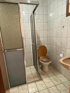 a bathroom with a toilet and a glass shower at Chalés 4 Estações in Monte Verde +40 photos