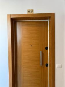 a wooden door with a sign on top of it at AP Apartment in Tirana