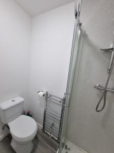 a bathroom with a toilet and a shower at Generous double bedroom with ensuite - home from home! in Birmingham +2 photos