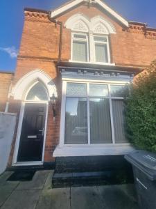 a brick house with a large window and a door at Generous double bedroom with ensuite - home from home! in Birmingham