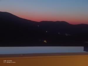 a view of a sunset with mountains in the background at Celini villa Tinos in Krokos