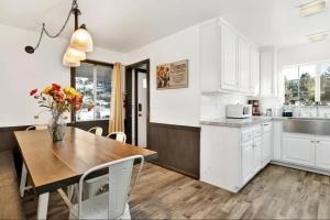 a kitchen with a wooden table and white cabinets at The ranch house #2501 in Sugarloaf