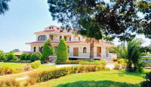 a large white house with trees and bushes at Dionysus Residence Pikermi in Pikérmion