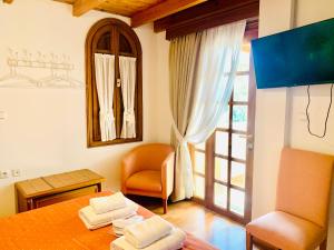 a room with a bed and a chair and a window at Dionysus Residence Pikermi in Pikérmion