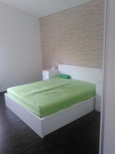 a bedroom with a bed with a green blanket on it at Ferienwohnung zum Kletterturm in Kaufbeuren