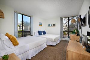 una camera da letto con due letti, una tv e una finestra di Oceanside Beach Condos a Oceanside