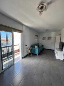 a living room with a blue couch and a refrigerator at Apartamento Celma in Adeje