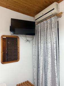 a room with a television and a curtain at AVRA Rooms in Therma