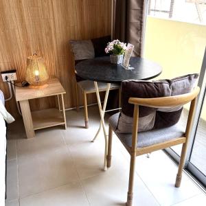 a table with two chairs and a table with flowers on it at the stay bangsaen in Ban Rong Khoei