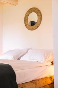 una camera da letto con un letto con uno specchio sul muro di Casa de Sus - Pe Dealul Mieilor - Cabană în Măguri, Cluj a Măguri