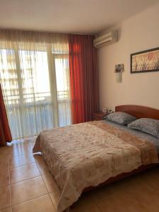 a bedroom with a large bed and a window at Central Plaza Apartment in Sunny Beach