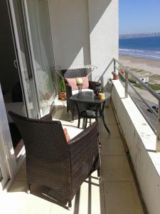 Un balcón con mesa y sillas y el mar. en Departamento en Condominio Mar Serena, en La Serena