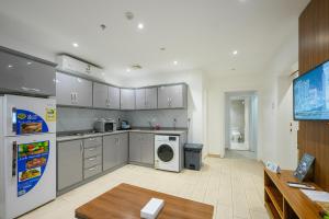 a large kitchen with a washer and dryer in it at Afaq Al Marsa For Furnished Apartments in Medina