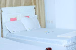 a white bed with white pillows on top of it at Parklands arena in Nairobi