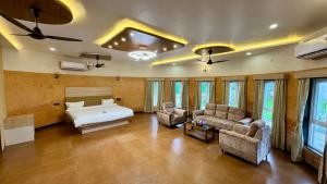a bedroom with a bed and a couch and chairs at Casa Nada Beach Villa in Udupi