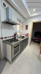 a kitchen with a stove and a counter top at Residence Golden Beach in Bin Rhilouf